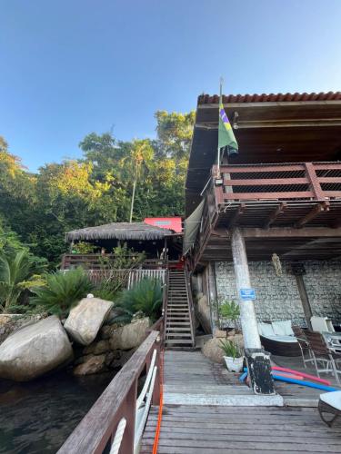 a building with stairs and a flag on it at Pousada Convés - Ilha Grande in Praia de Araçatiba