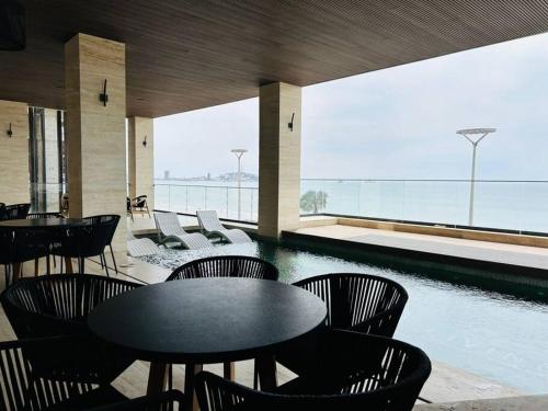 a restaurant with tables and chairs and a swimming pool at frente al malecón, 5 min zona dorada by G P S rentas in Mazatlán