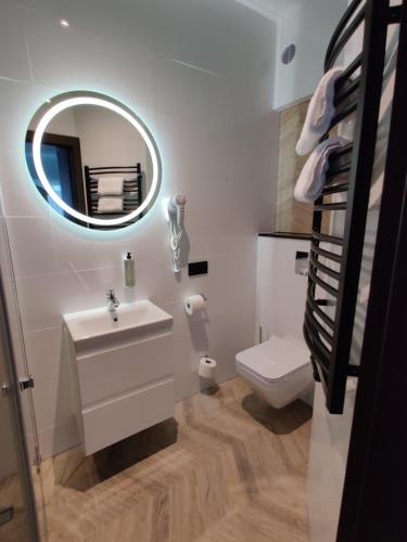 W łazience znajduje się umywalka, lustro i toaleta. w obiekcie Nowe M4 Żyrardów Centrum - blisko Suntago w mieście Żyrardów