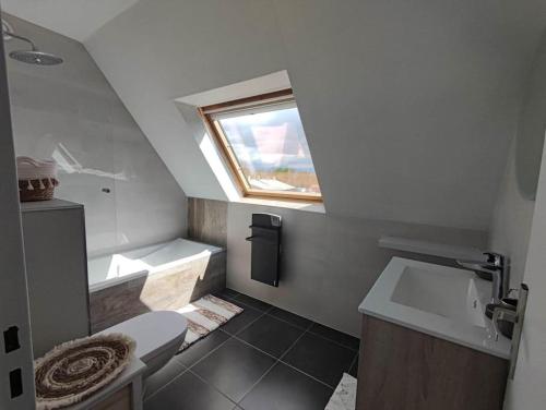 ein Bad mit einem WC, einem Waschbecken und einem Fenster in der Unterkunft GITE W 
