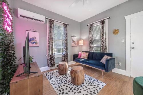 a living room with a blue couch and a tv at Jungle Themed Apt. Close to Coffee, Food + Shops! in Tampa
