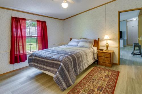 1 dormitorio con 1 cama con cortinas rojas y espejo en Upstate NY Vacation Rental 1 Mi to Fairhaven Beach, en Red Creek