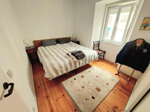 a bedroom with a bed with a rug and a window at Cosy Apartment in Central Lisbon in Lisbon