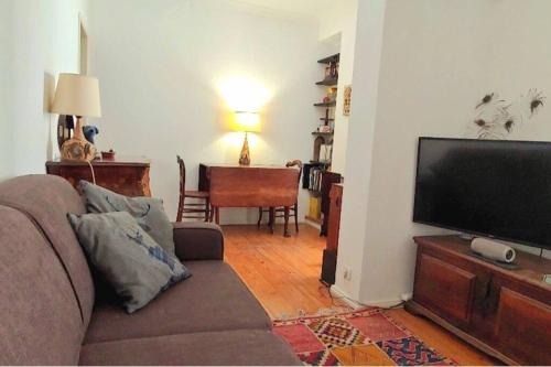 a living room with a couch and a flat screen tv at Cosy Apartment in Central Lisbon in Lisbon