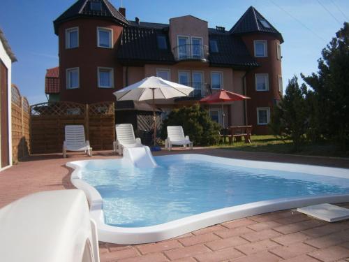 a swimming pool in front of a house at Atlantic aqua resort in Chłopy