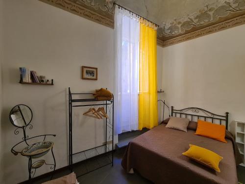 佩魯賈的住宿－Casa dei Gigli，一间卧室设有床和黄色窗帘的窗户