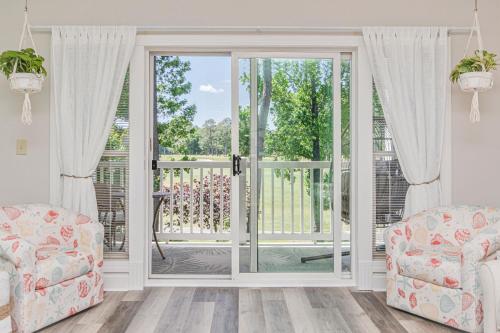 a living room with doors open to a balcony at The Salty Fairway, Golf Course Condo with Resort Style Pool, 5 Miles from Beach, Fully updated in Myrtle Beach