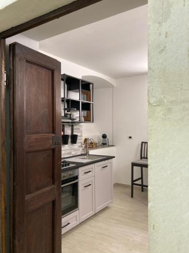 a kitchen with white cabinets and a wooden door at la dimora san marciano in LʼAquila