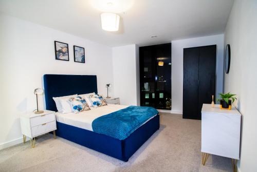 Schlafzimmer mit einem blauen und weißen Bett und einem Fenster in der Unterkunft Beautiful place - 2 Bedroom Apartment on Broad Street in Birmingham