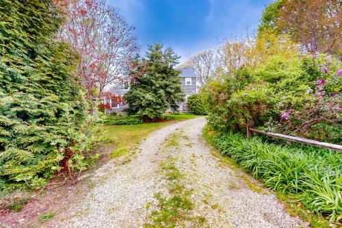 a dirt road in a yard with trees and bushes at Family Tides in Barnstable
