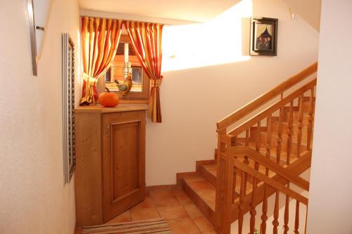 a staircase in a house with an orange pumpkin in the window at Das GÄSTEHAUS SCHNEIDER am Dorfplatz in Alpbach