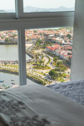 a view of a city from a bedroom window at private ocean view studio apartment in Panama City