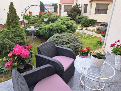 a patio with two chairs and a table with flowers at Vila Ambient frontal la mare in Mamaia Sat/Năvodari