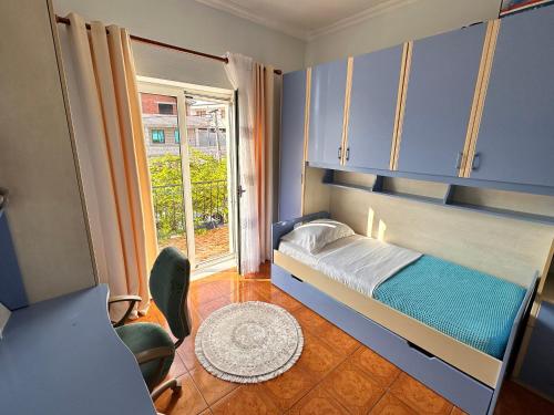 a bedroom with a bed with blue cabinets and a window at Hotel Kalaja in Shkodër