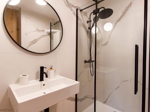 y baño con lavabo y ducha. en VacationClub – Sosnowa 4 Apartament 26 en Mielno