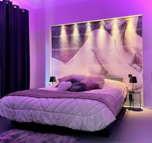 Dormitorio púrpura con cama con cabecero grande en Domaine de l'Angélique - Loft avec SPA privatif - Marais poitevin entre Niort et La Rochelle, en Arçais