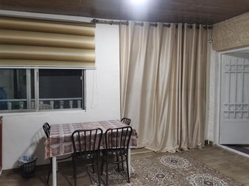 a dining room with a table and chairs and a window at Studeo for rent in Amman