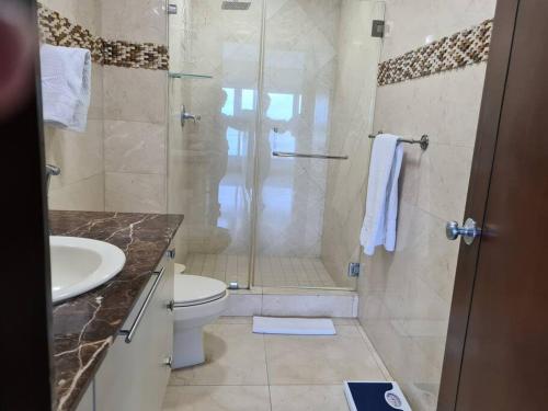 a bathroom with a shower and a toilet and a sink at Amplio y hermoso apartamento frente a la bahía. in Panama City