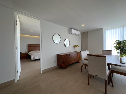 a dining room with a table and a bedroom at frente al malecón, 5 min zona dorada by G P S rentas in Mazatlán