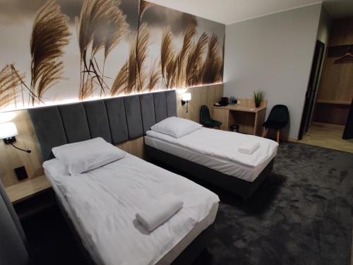 a hotel room with two beds and a desk at Nowe M4 Żyrardów Centrum - blisko Suntago in Żyrardów