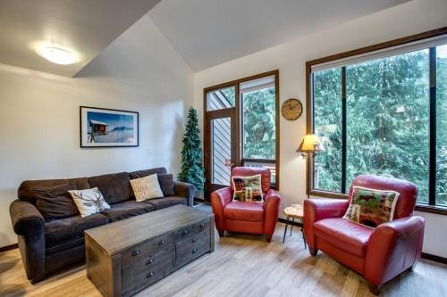 ein Wohnzimmer mit einem Sofa und 2 Stühlen in der Unterkunft 06SW - Fireplace - WithD - Kitchen - Sleeps 7 home in Glacier