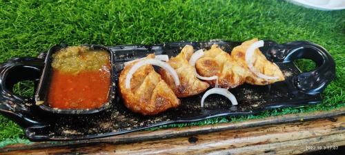 a plate of food with onion rings and sauce at Paradise guest view in Nandaprayāg