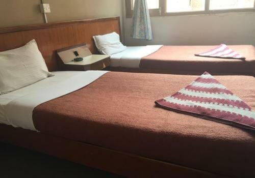 een hotelkamer met 2 bedden en een kussen bij Paradise guest view in Nandaprayāg