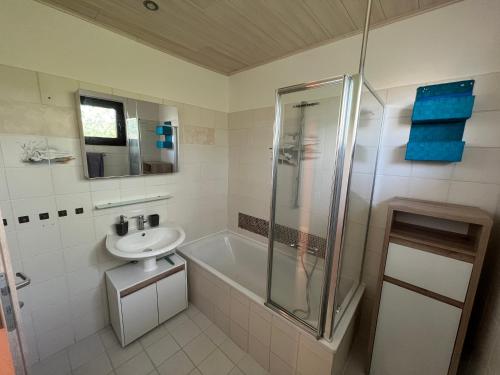 文斯托夫的住宿－Fewo am Wald，带淋浴、盥洗盆和浴缸的浴室