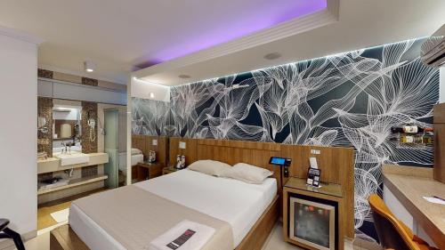 a bedroom with a bed and a bathroom at Motel DUBAI BH in Belo Horizonte