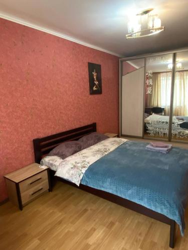 sypialnia z dużym łóżkiem i lustrem w obiekcie Apartment in Shoduar's park w mieście Żytomierz