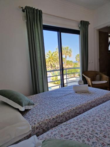 a bedroom with a bed with a view of the ocean at Beachfront house,Manta Rota,Algarve in Vila Nova De Cacela