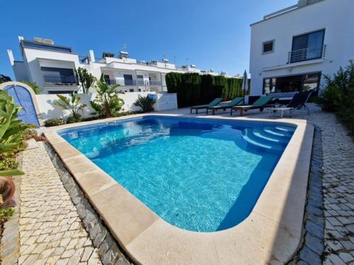 a swimming pool with blue water in a yard at Beachfront house,Manta Rota,Algarve in Vila Nova De Cacela
