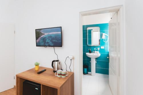 een badkamer met blauwe muren, een wastafel en een aanrecht bij Hotel Tier Center in Tirana