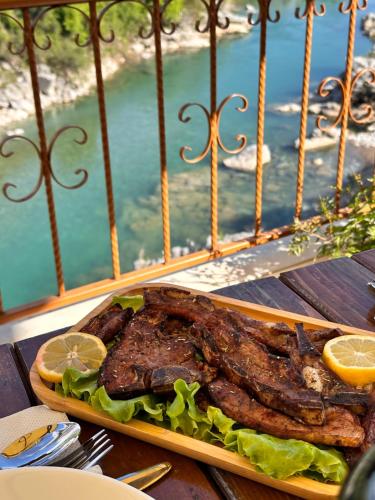 a plate of food with a steak on a table at Hotel Kalaja in Shkodër