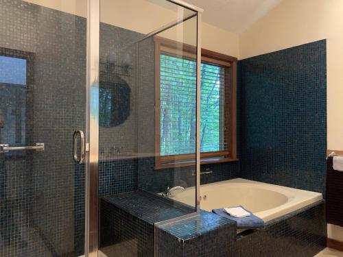 La salle de bains est pourvue d'une baignoire et d'une douche en verre. dans l'établissement New Mcferson Located In Alphine Lake Resort, à McComas Beach