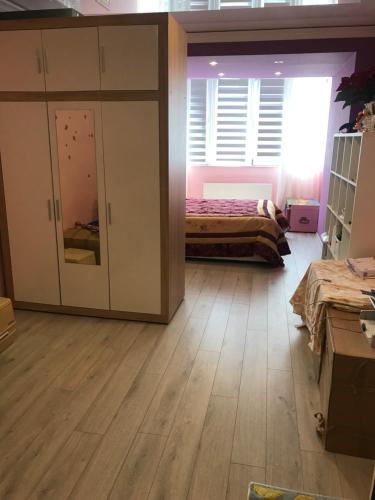 1 dormitorio con 1 cama y 1 habitación grande con suelo de madera. en Cozy Retreat in Quiet Location, en Chişinău
