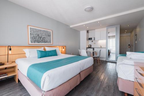 a hotel room with two beds and a kitchen at Punta Trouville Hotel in Montevideo