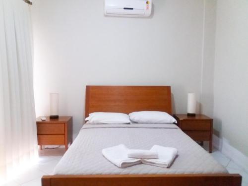 a bedroom with a bed with two towels on it at Pipa Brisas do Amor in Pipa