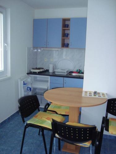 een keuken met een tafel en stoelen en een tafel en een tafel bij Silver Apartman Patince in Patince