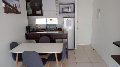 cocina con mesa blanca y sillas en Departamento, Apartamento económico en La Serena, en La Serena