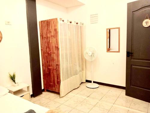 a bedroom with a shower and a fan in a room at La Maison Guesthouse in Manlocahoc