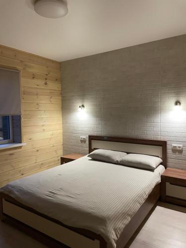 a bedroom with a large bed and two night stands at Fest House in Svityazʼ