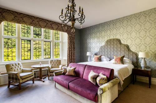 Un dormitorio con una cama grande y un sofá púrpura. en Bovey Castle, en Moretonhampstead