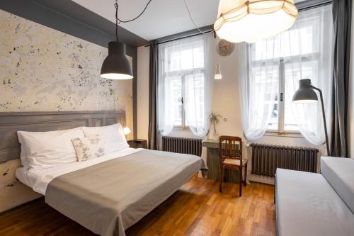 a bedroom with a bed and two windows at Miss Sophie's New Town & Wellness in Prague