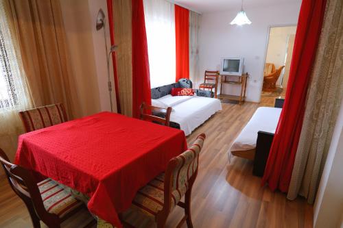Pokój z 2 łóżkami, czerwonym stołem i krzesłami w obiekcie Sobe Milinka w mieście Sokobanja