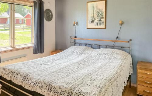 una camera da letto con un letto e un piumone bianco di Nice Home In Vittaryd With 2 Bedrooms And Wifi a Kvänarp