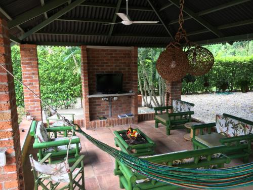 a patio with a hammock and a fire pit at Casa Guali in Honda