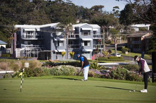 two people playing golf on a golf course at Mollymook Cove Apartments in Mollymook
