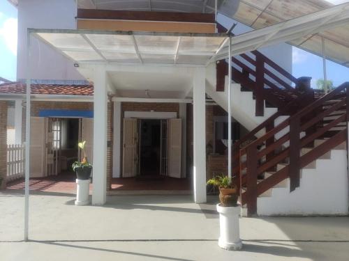 a house with a staircase and potted plants on the porch at Renoah Pousada in Ubatuba