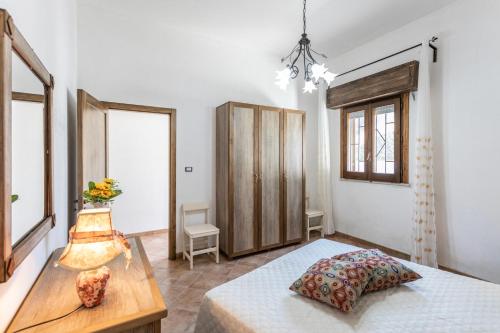 a bedroom with a bed and a table and windows at Villetta Mariangela in Capilungo